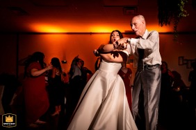 A bride dances with her grandfather at her wedding reception in Essa, Ontario. The portrait captures a candid moment between the two.